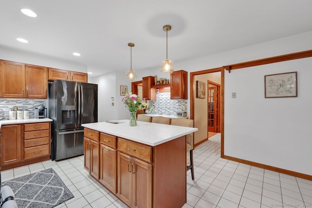 9 Pheasant Run, Granby, CT 06060 - kitchen featuring black fridge, tasteful backsplash, light tile patterned flooring, light countertops, and a kitchen island
