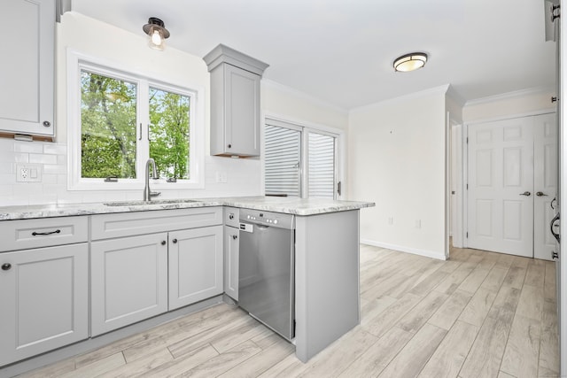 kitchen with dishwasher, a sink, crown molding, decorative backsplash, and light wood finished floors