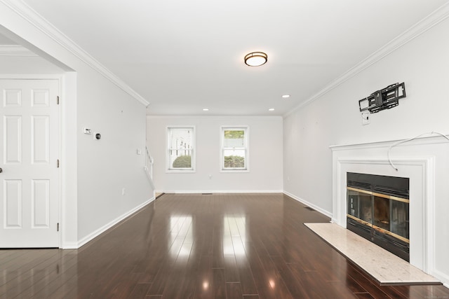 unfurnished living room featuring a glass covered fireplace, baseboards, ornamental molding, dark wood finished floors, and recessed lighting