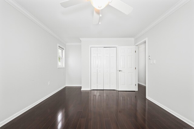 unfurnished bedroom with crown molding, wood finished floors, baseboards, a closet, and a ceiling fan