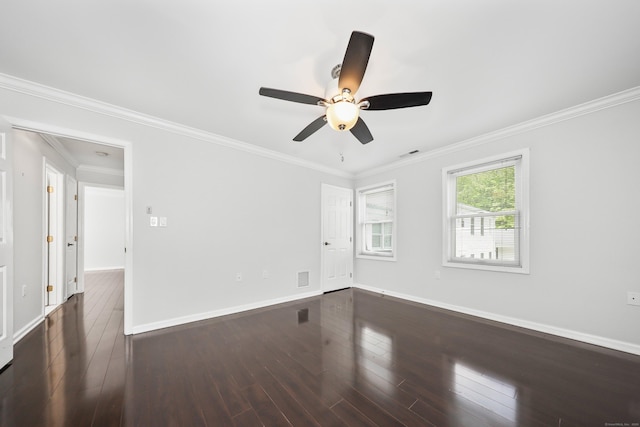 unfurnished room featuring dark wood-type flooring, a ceiling fan, baseboards, and crown molding