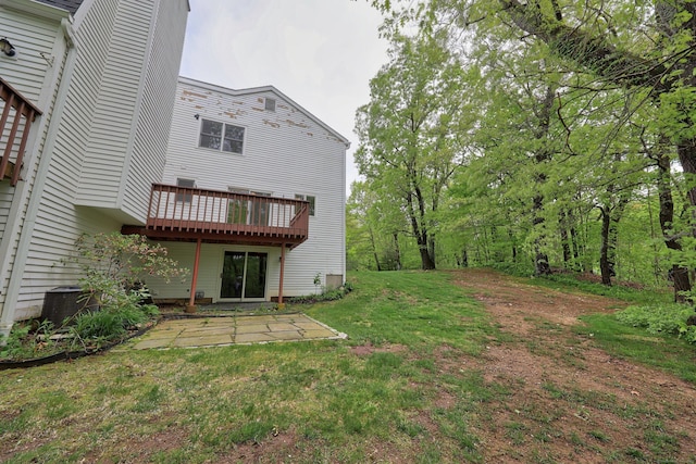 view of green lawn with a patio area and a deck