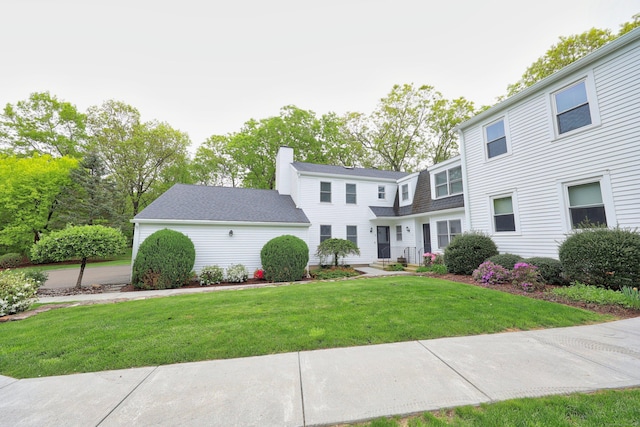 view of front of home with a front lawn and a chimney
