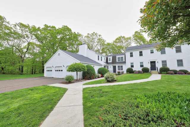 view of front of home featuring driveway, a garage, and a front yard