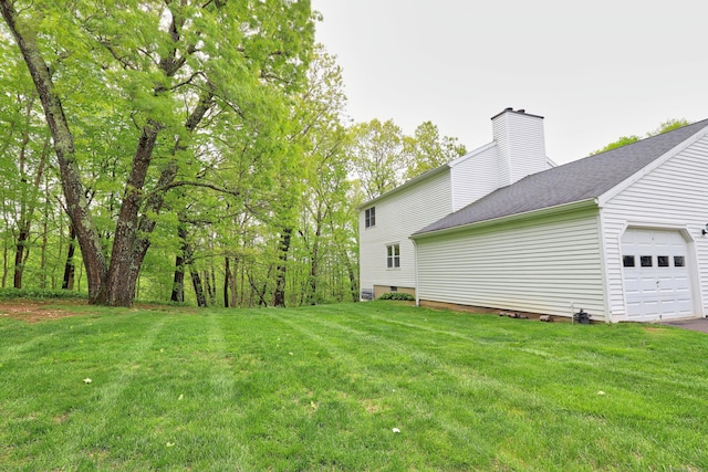 view of green lawn featuring a garage