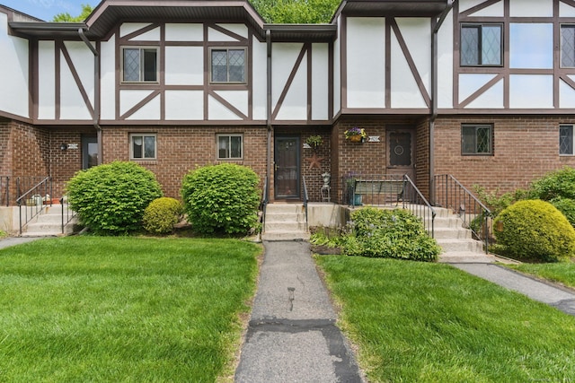 404 Cedar Hollow Dr Unit 404, Rocky Hill, CT 06067 - tudor home with stucco siding, a front yard, and brick siding