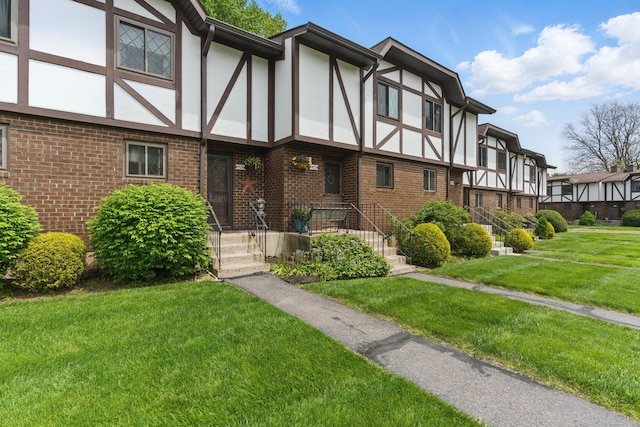 404 Cedar Hollow Dr Unit 404, Rocky Hill, CT 06067 - tudor-style house with stucco siding, brick siding, a front lawn, and a residential view