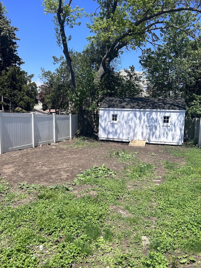 view of yard featuring a storage unit, fence, and an outdoor structure
