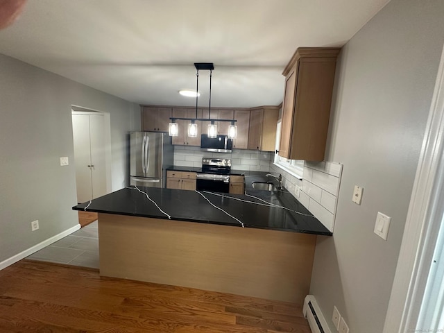 kitchen featuring appliances with stainless steel finishes, dark countertops, a sink, and backsplash