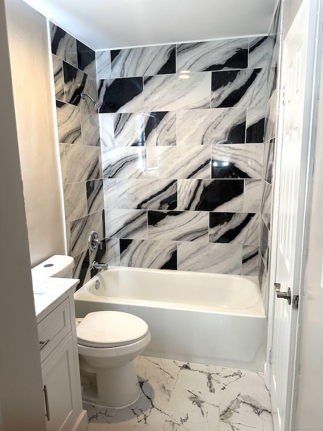 bathroom with tub / shower combination, toilet, vanity, and marble look tile flooring
