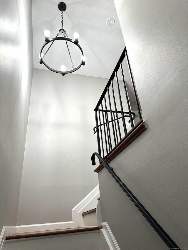 stairway featuring a chandelier