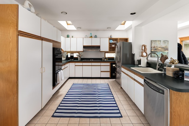 5 New Street Ext, Wilton, CT 06897 - kitchen featuring black appliances, a sink, under cabinet range hood, a skylight, and dark countertops