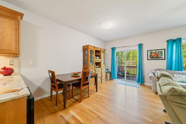 dining area featuring light wood-style flooring and baseboards