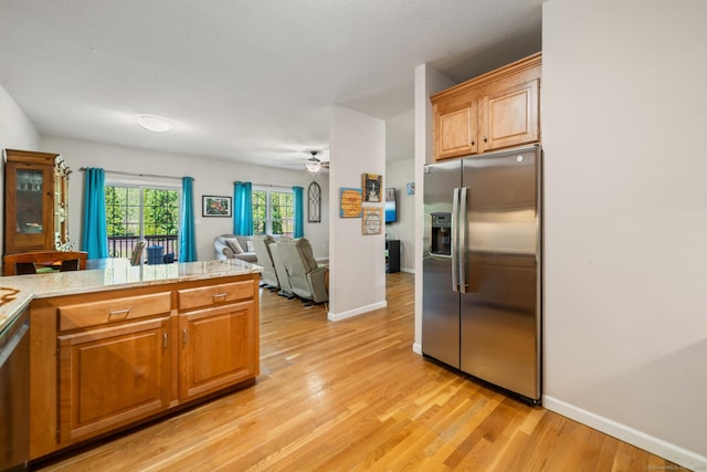 kitchen featuring appliances with stainless steel finishes, light wood finished floors, baseboards, and ceiling fan