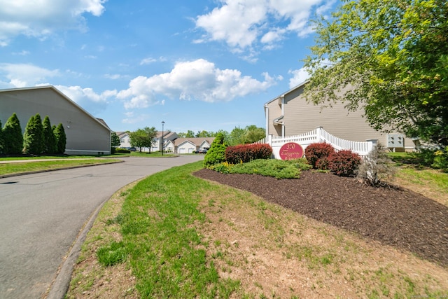 view of asphalt road with curbs and a residential view