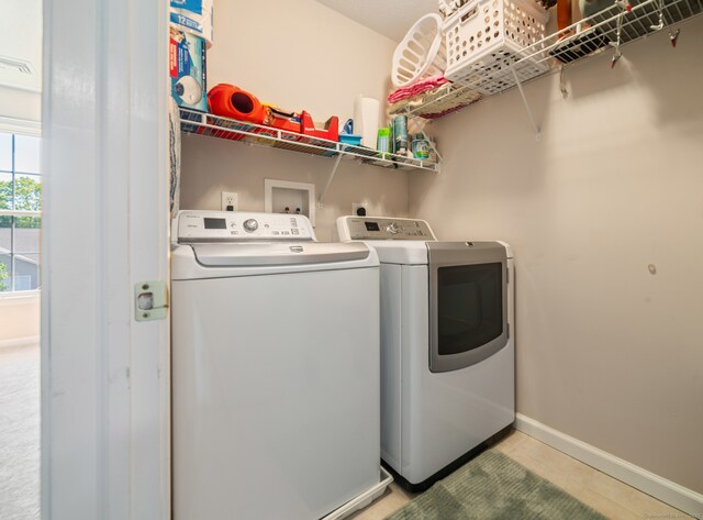washroom featuring separate washer and dryer, baseboards, and tile patterned floors
