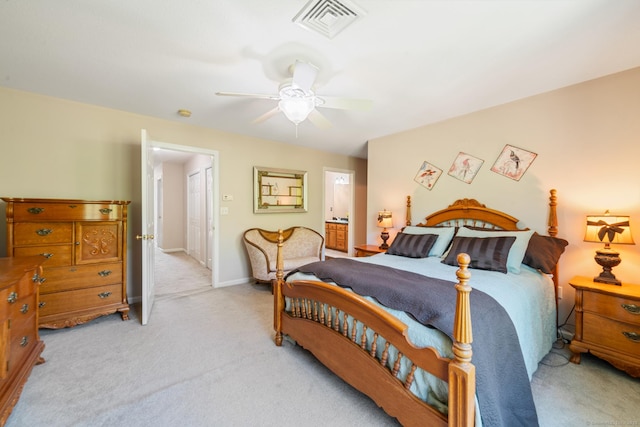 bedroom with light carpet, ceiling fan, baseboards, and ensuite bath