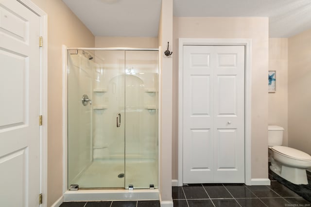 full bathroom featuring tile patterned flooring, a shower stall, toilet, and baseboards