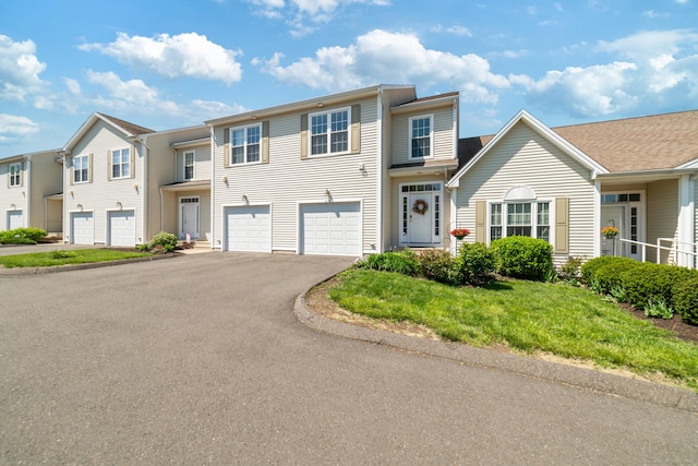 multi unit property featuring asphalt driveway and a garage
