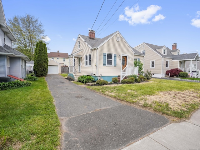 31 Emerson St, Norwalk, CT 06855 - view of front of property featuring an outbuilding, a chimney, a front lawn, a garage, and central AC