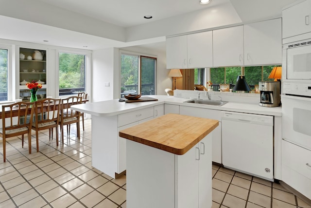 32 Beeholm Rd, Redding, CT 06896 - kitchen featuring white appliances, a peninsula, a sink, light tile patterned floors, and recessed lighting