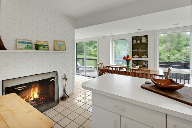 32 Beeholm Rd, Redding, CT 06896 - kitchen with light tile patterned flooring, a fireplace, healthy amount of natural light, and light countertops