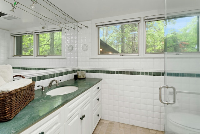 32 Beeholm Rd, Redding, CT 06896 - full bath featuring tile walls, vanity, healthy amount of natural light, an enclosed shower, and tile patterned flooring