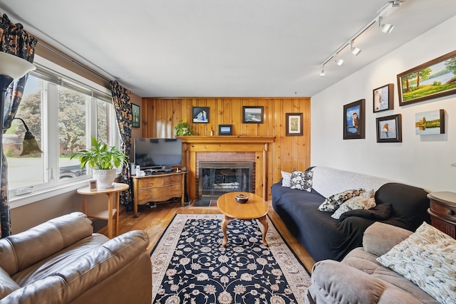 149 Edgewood Dr, Torrington, CT 06790 - living area featuring wood finished floors, a brick fireplace, wooden walls, and track lighting