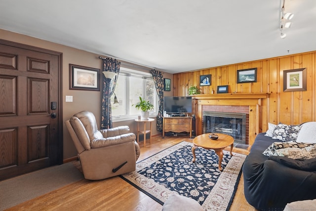 149 Edgewood Dr, Torrington, CT 06790 - living area with a brick fireplace, light wood finished floors, and wooden walls