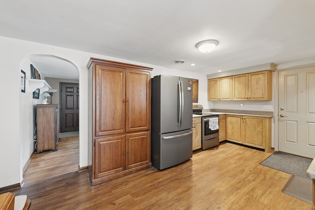 149 Edgewood Dr, Torrington, CT 06790 - kitchen with stainless steel appliances, arched walkways, light wood-style floors, light countertops, and recessed lighting