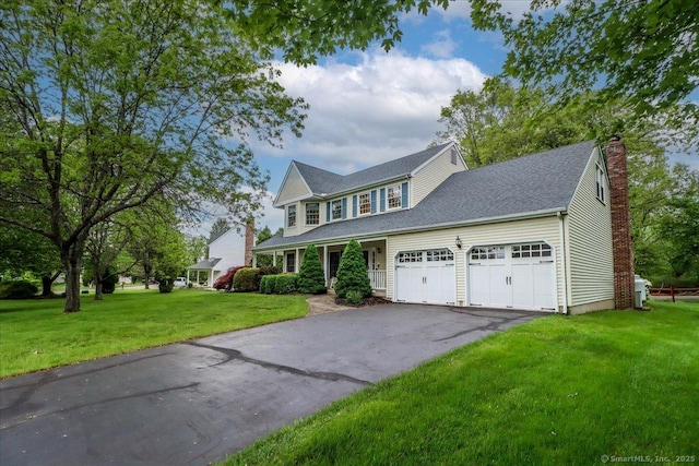 9 Rosick Rd, Wallingford, CT 06492 - colonial house with an attached garage, asphalt driveway, a front lawn, a chimney, and covered porch
