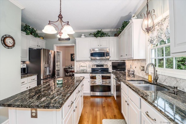 9 Rosick Rd, Wallingford, CT 06492 - kitchen featuring stainless steel appliances, a sink, a chandelier, white cabinets, and tasteful backsplash