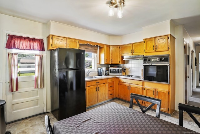 90 Russell Rd, Stratford, CT 06614 - kitchen featuring black appliances, under cabinet range hood, tasteful backsplash, a sink, and light countertops