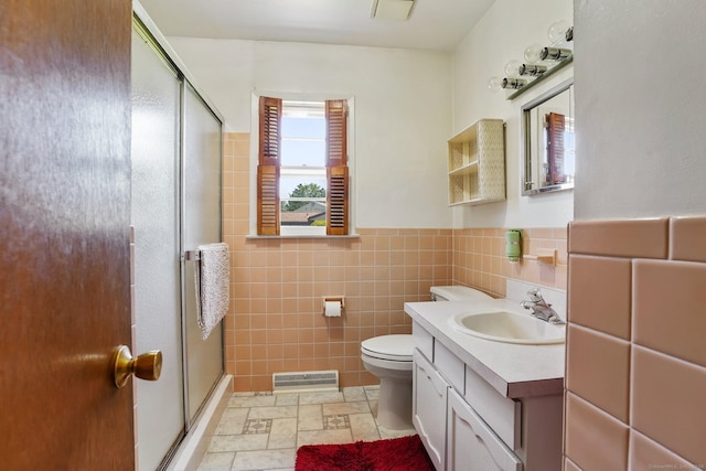 90 Russell Rd, Stratford, CT 06614 - bathroom featuring a shower stall, vanity, toilet, tile walls, and a wainscoted wall