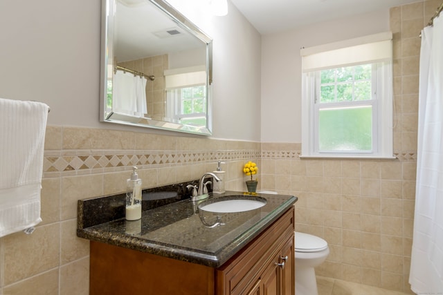 27 Lansing Ave, Trumbull, CT 06611 - bathroom with tile walls, healthy amount of natural light, a wainscoted wall, vanity, and toilet