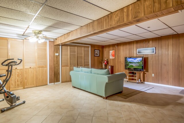 27 Lansing Ave, Trumbull, CT 06611 - living room featuring a paneled ceiling, ceiling fan, wooden walls, and baseboards
