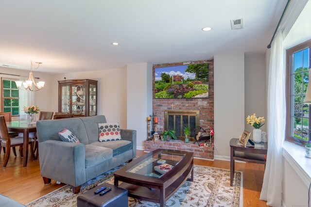 27 Lansing Ave, Trumbull, CT 06611 - living room featuring light wood-type flooring, a chandelier, a brick fireplace, recessed lighting, and baseboards