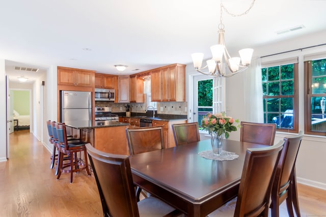 27 Lansing Ave, Trumbull, CT 06611 - dining area with a chandelier, light wood-style flooring, and baseboards
