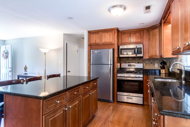 27 Lansing Ave, Trumbull, CT 06611 - kitchen featuring stainless steel appliances, a sink, light wood-type flooring, tasteful backsplash, and brown cabinets