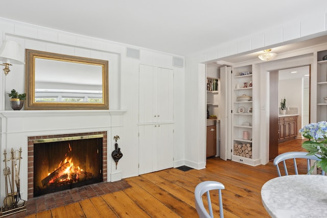336 Old Branchville Rd, Ridgefield, CT 06877 - dining area with hardwood / wood-style flooring, a fireplace, and built in features