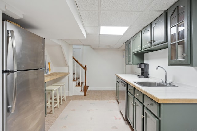 336 Old Branchville Rd, Ridgefield, CT 06877 - kitchen with stainless steel appliances, a sink, baseboards, a paneled ceiling, and tile countertops