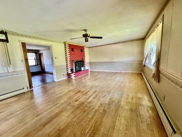 343 Lebanon Ave, Lebanon, CT 06249 - unfurnished living room featuring a baseboard heating unit, a textured ceiling, light wood-style floors, ceiling fan, and a brick fireplace