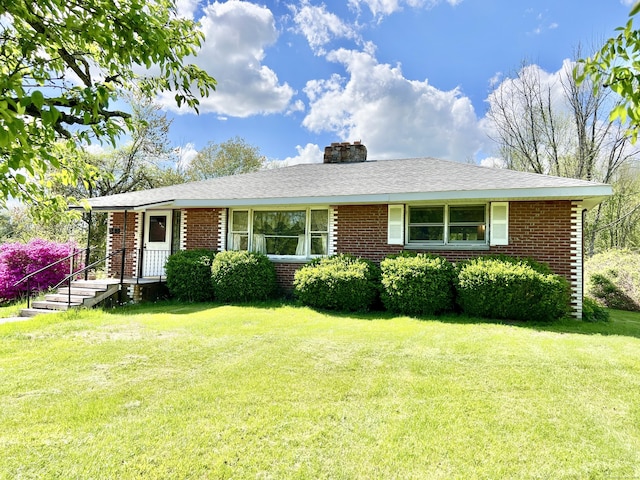343 Lebanon Ave, Lebanon, CT 06249 - view of front of house featuring brick siding, a front lawn, and a chimney
