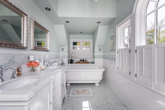55 Lake Dr S, New Fairfield, CT 06812 - full bath featuring wainscoting, a freestanding bath, tile walls, speckled floor, and double vanity