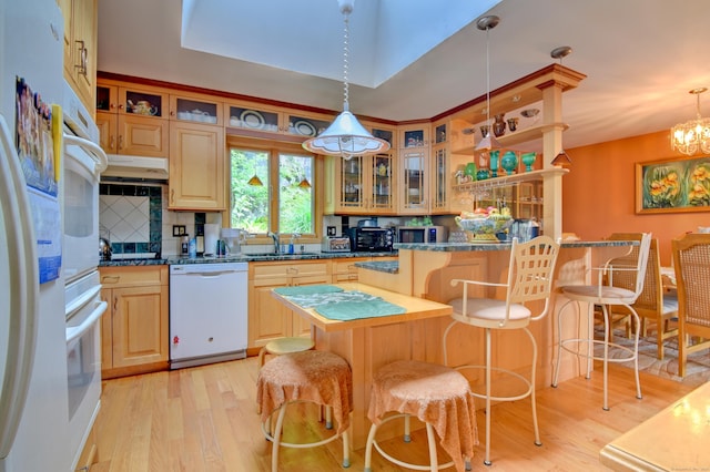 5 Yochers Ln, Derby, CT 06418 - kitchen featuring white appliances, light wood finished floors, a kitchen bar, dark countertops, and under cabinet range hood
