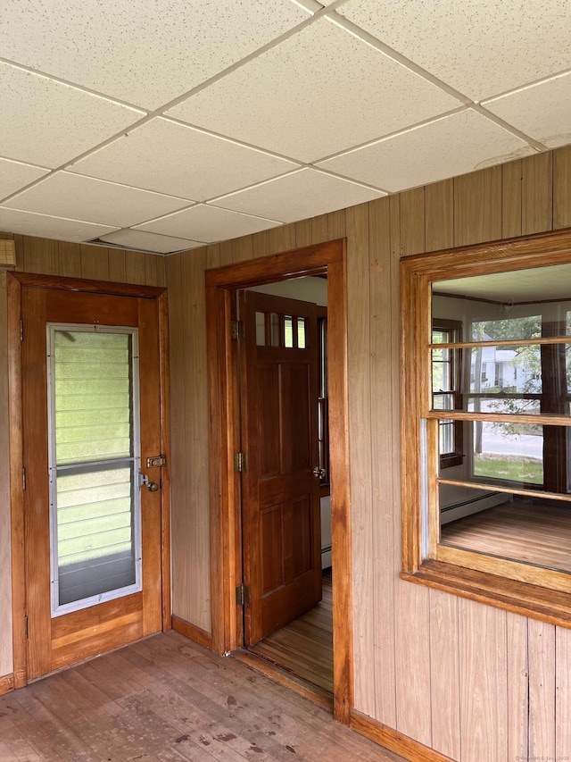 1092 Plainfield Pike, Sterling, CT 06373 - empty room with a drop ceiling, wood-type flooring, baseboards, wood walls, and baseboard heating