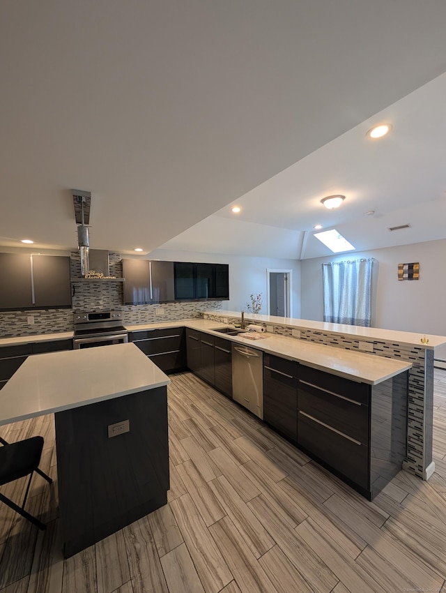 kitchen featuring stainless steel appliances, modern cabinets, tasteful backsplash, and recessed lighting
