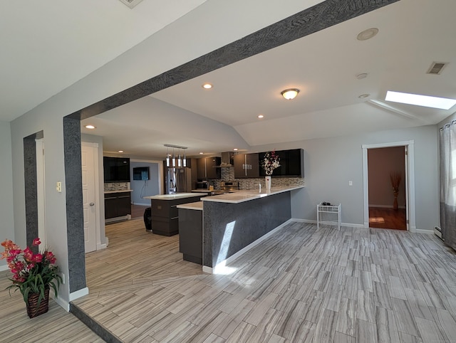 9 Washington Rd, Windsor, CT 06095 - kitchen with vaulted ceiling, decorative backsplash, light countertops, wood tiled floors, and a peninsula