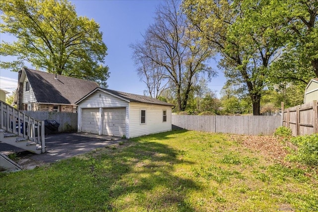 view of yard featuring a garage and an outbuilding