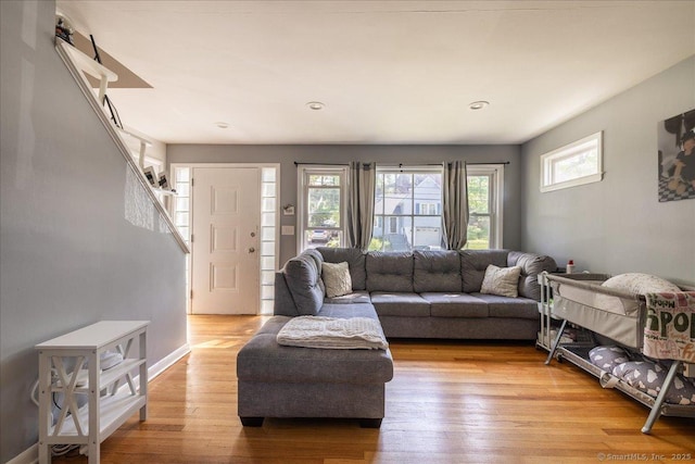 living room with light wood-style floors, recessed lighting, and stairway